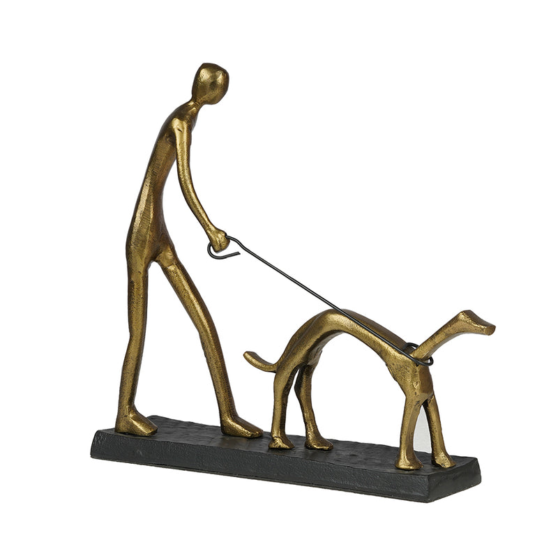 Table top metal sculpture of a man walking a dog, in a white background.