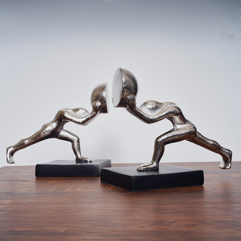 Metallic silver colored bookends set of 2 human figures pushing from opposite direction.