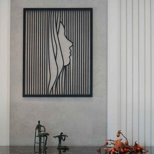 Large metallic black colored wall art showing face of a lady in modern design.