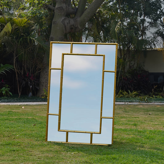 Front view of a large rectangular metallic mirror in a bamboo themed frame with a reflection of clear blue sky.