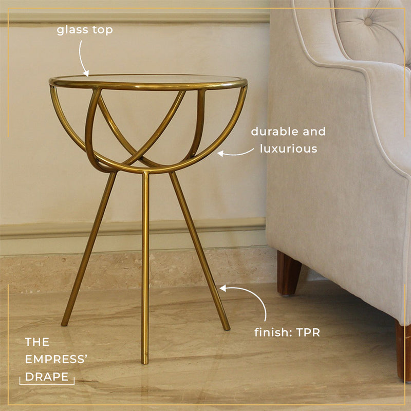 Close-up view of a modern design golden colored metallic side table with a glass top and product features mentioned.