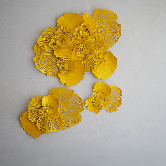 Set of 3 yellow metallic wall art in the design of bouquets of flowers.