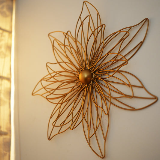 Close up image of a golden metallic wall art with intricate and beautiful wire pattern.