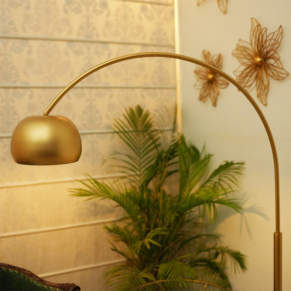 close up image of the curved top of an arched tall metallic floor lamp placed in a living room set-up.