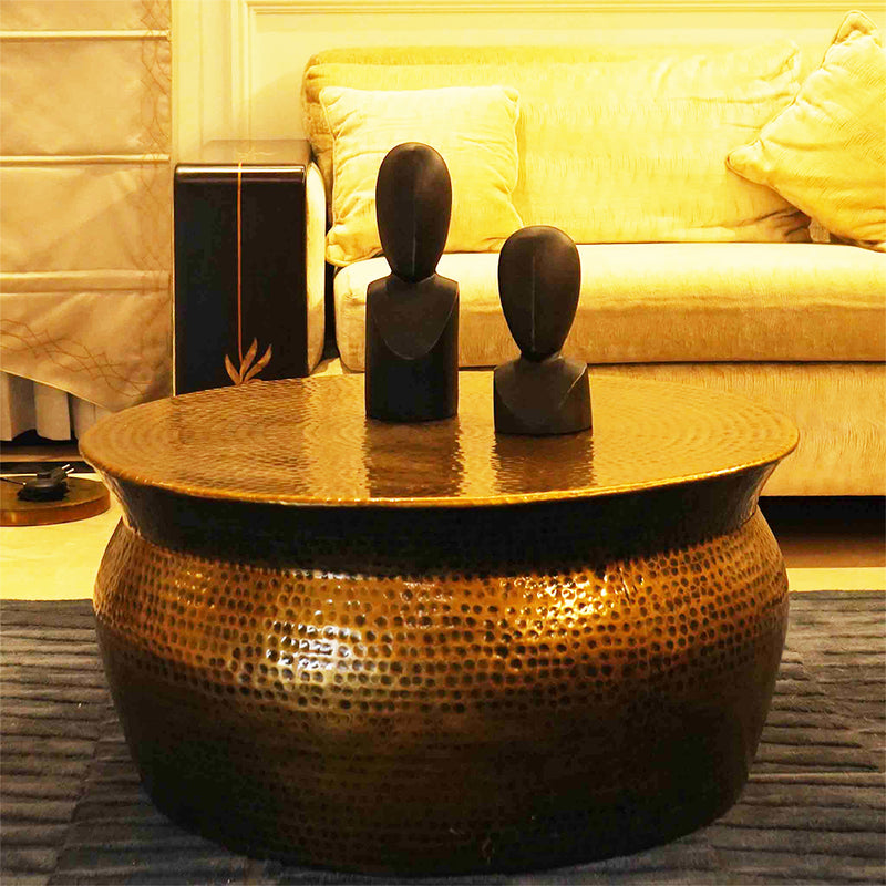 Handmade metallic round drum shape coffee table in antique copper finish in a close-up photo.