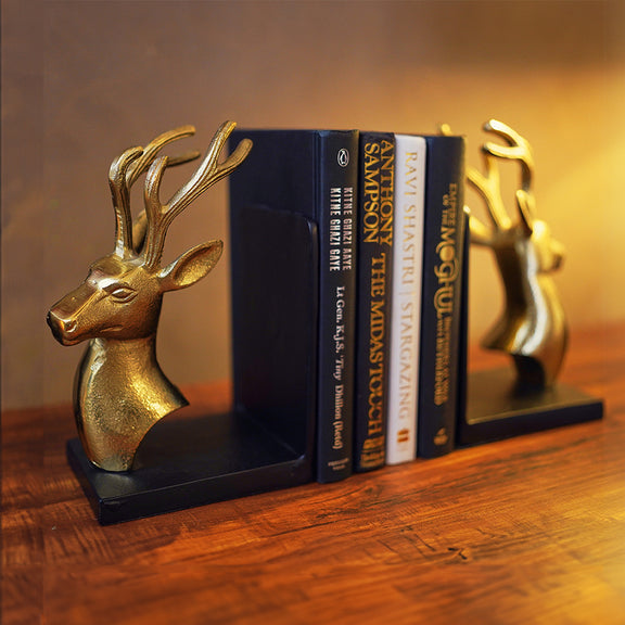 Bookends set of 2 in golden metallic deer head and antlers design with 4 books in between at a side angle.