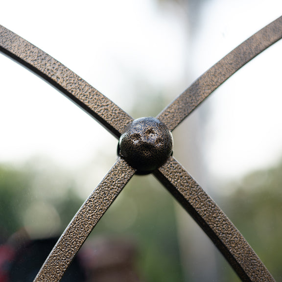 Close-up image of a hammerer metallic joint of a large mirror.