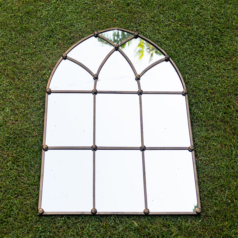 Top view image of a large copper metallic mirror shaped like a dome window.