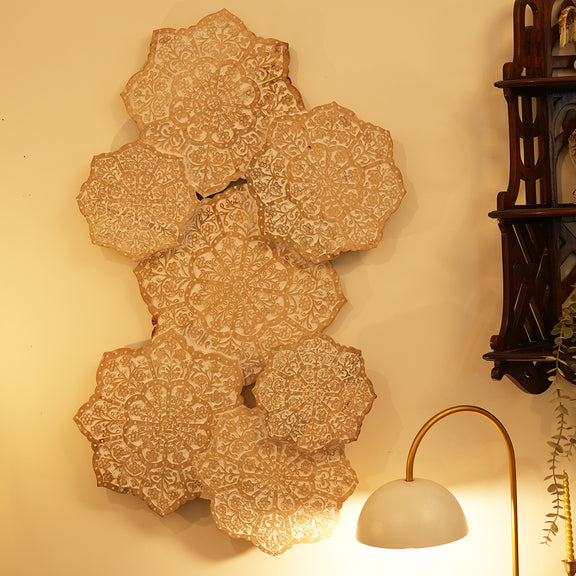 Wall art made of hand-carved mango wood hung vertically on the wall of a living room.