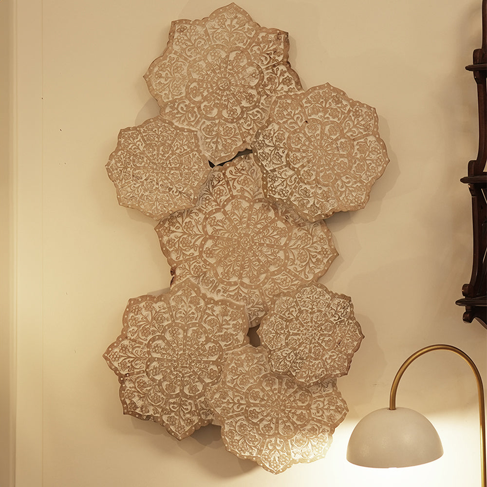 Wall art made of hand-carved mango wood hung vertically on the wall of a living room.