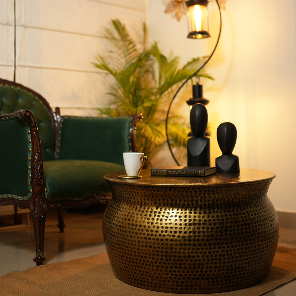 Handmade metallic round drum shape coffee table in antique copper finish is placed in a cozy living room.