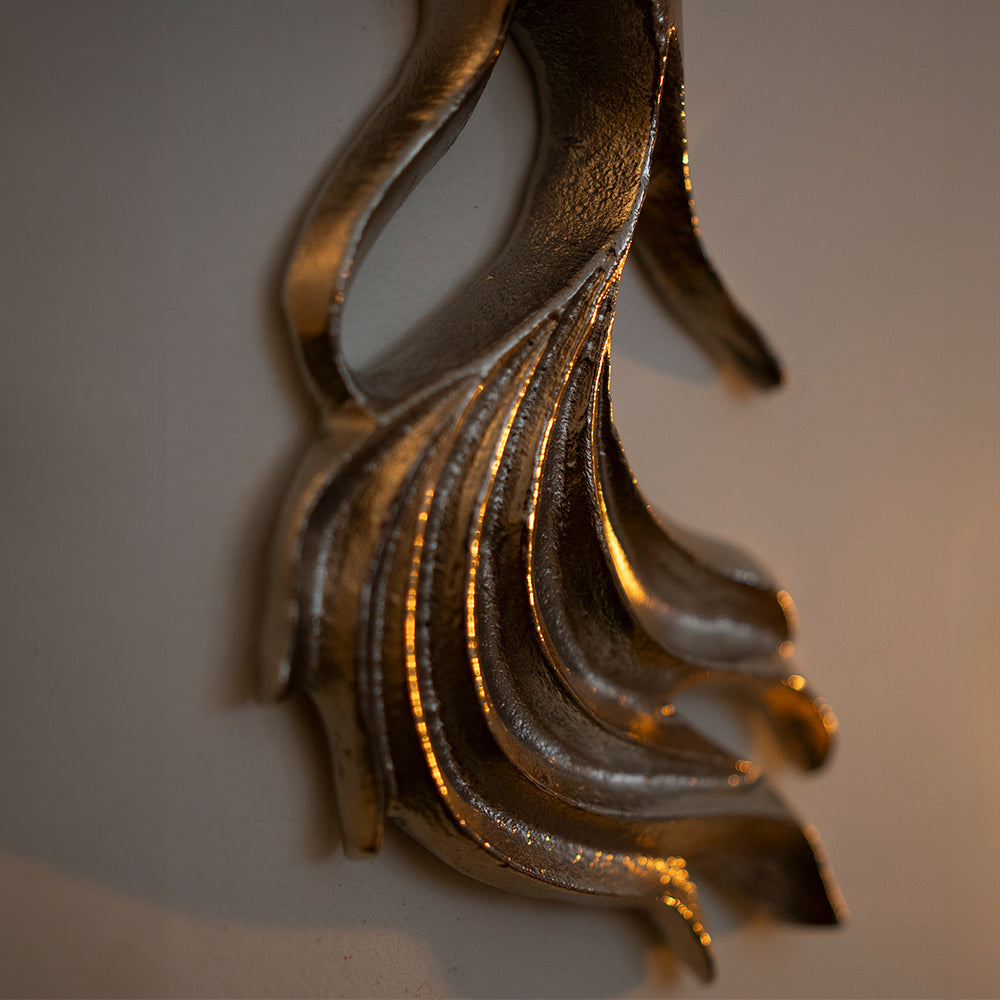 Close up image of the tail of a metallic wall art in fish shape and nickel chrome finish.