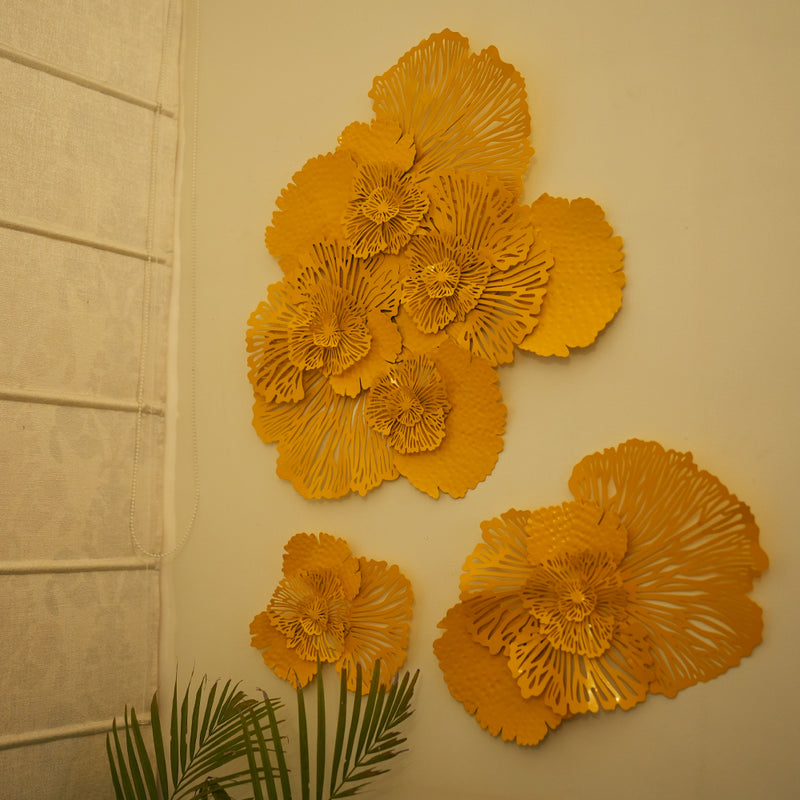 Set of 3 yellow metallic wall art in the design of bouquets of flowers.