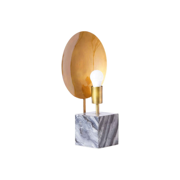 Side view of a modern design table lamp on a concrete base and a round metallic plate on the back of the bulb.