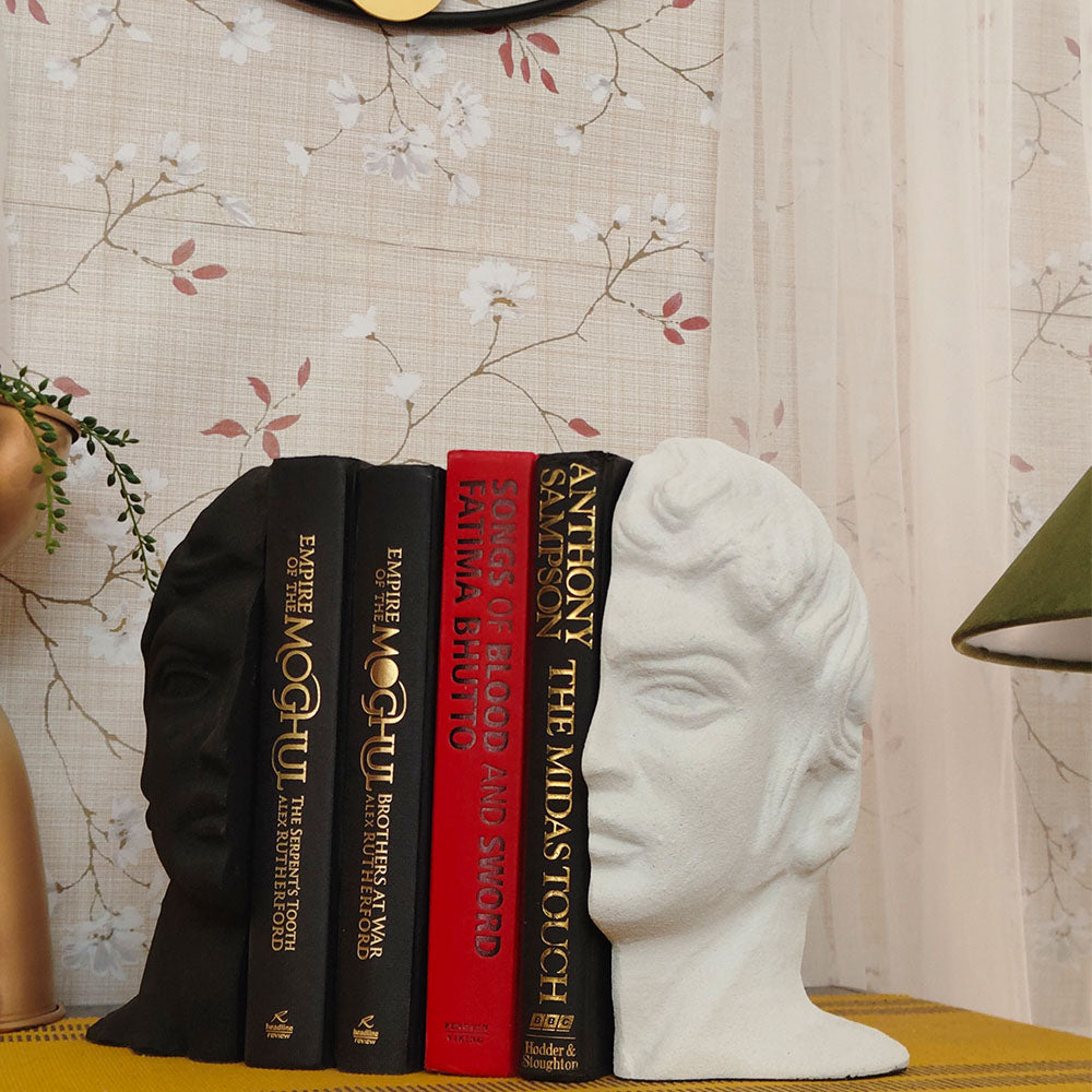Modern bookends set with a man's face split in half, black and white color with 4 books in between at a side angle.