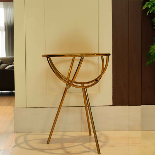 Close-up view of a modern design golden colored metallic side table with a glass top.
