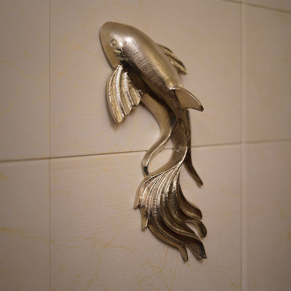 Close up image of a metallic wall art in fish shape and nickel chrome finish.