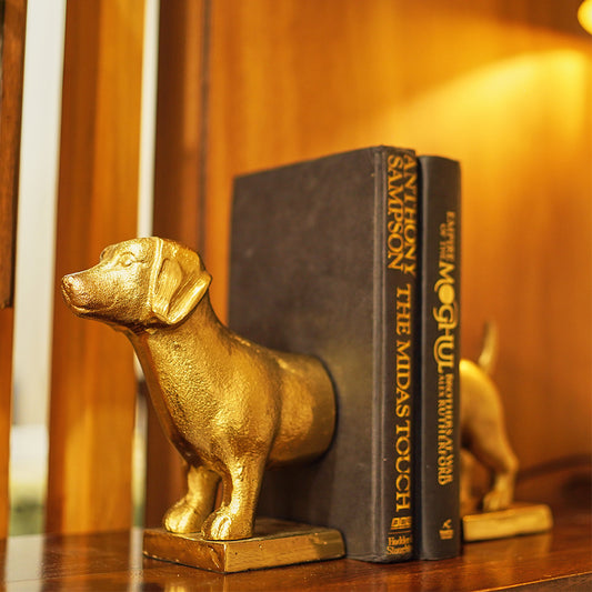 Side view of a metallic bookend which is in the shape of a dog.