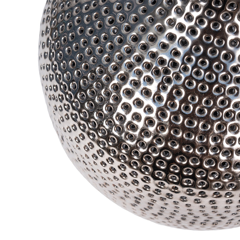 close up image of a handmade artisanal table lamp showing detailed perforations and holes on the metal's surface.