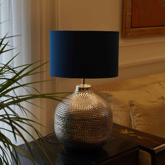 Handmade metal table lamp with holes design on the surface.