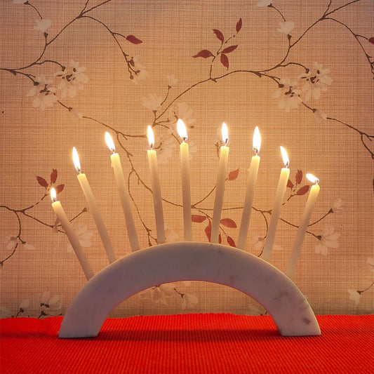 A white marble semi-circle slab as a candle holder with 9 burning candles.