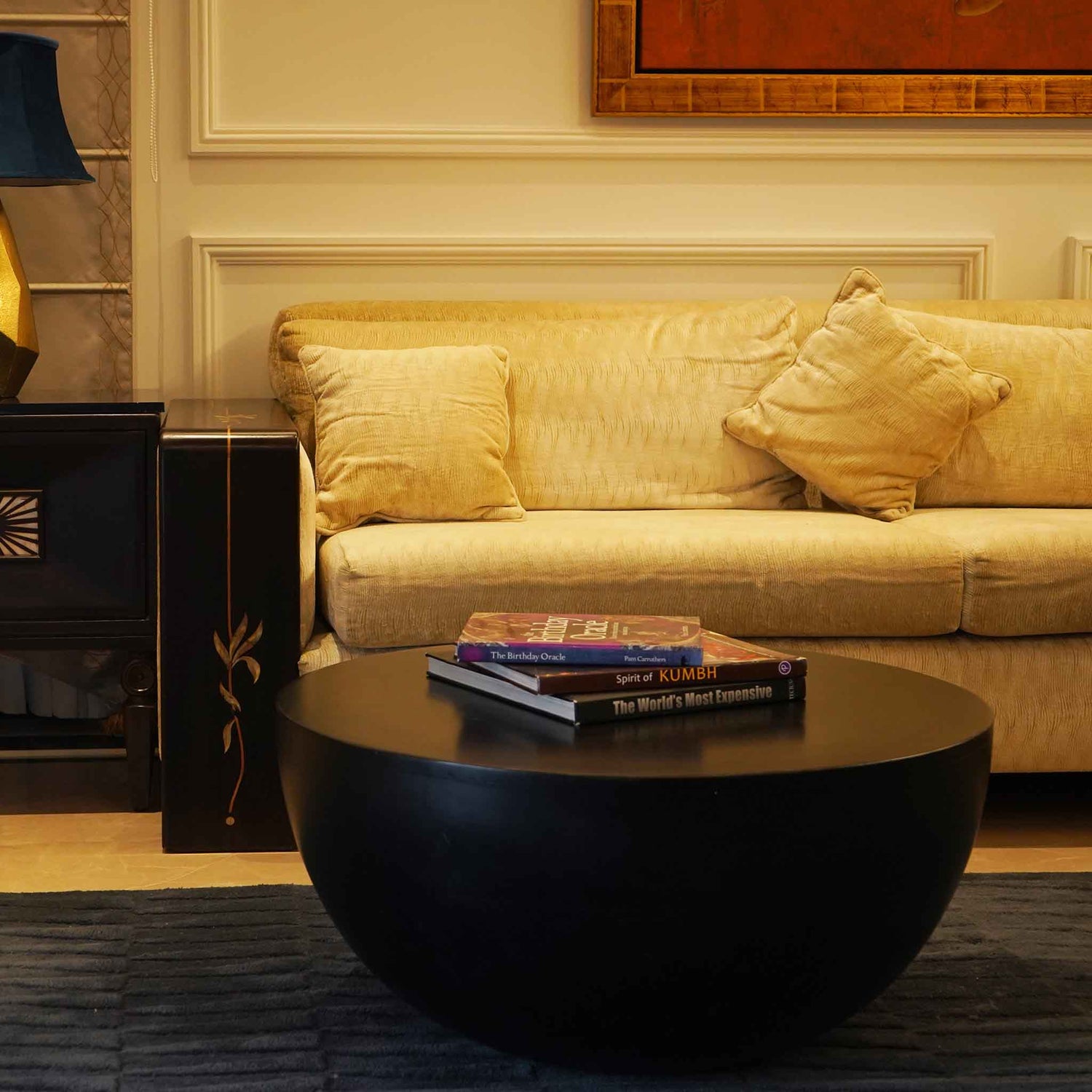 Black colored oval shape mango wood coffee table in a living room set-up.