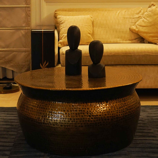 Handmade metallic round drum shape coffee table in antique copper finish in a close-up photo.