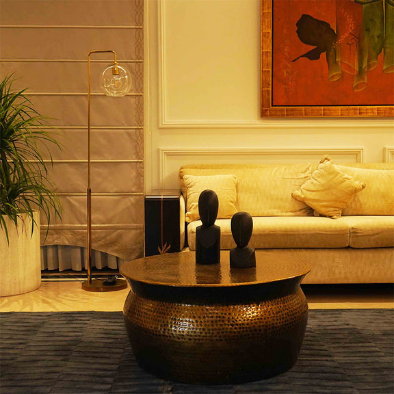 Handmade metallic round drum shape coffee table in antique copper finish in a living room set-up.