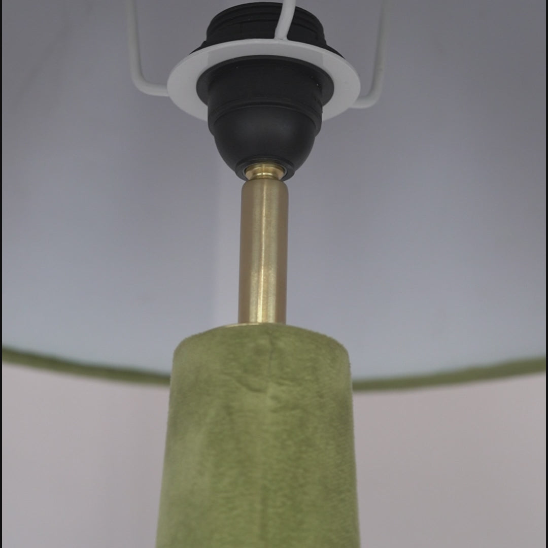 Close-up video showing stitching details of velvet on a green floor lamp.
