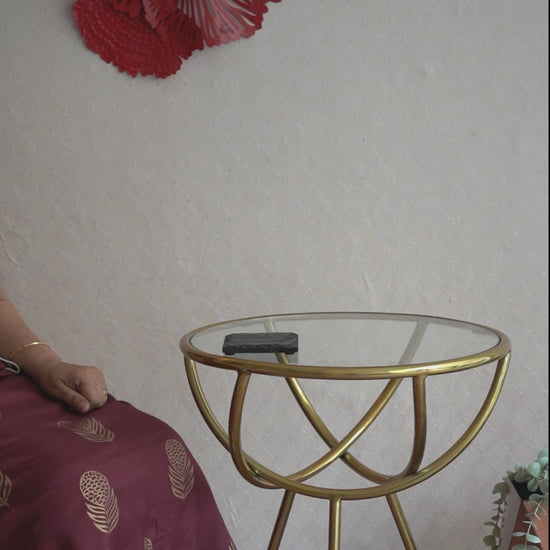 Video of a hand-model placing a cup on a slate coaster kept on a glass top table.