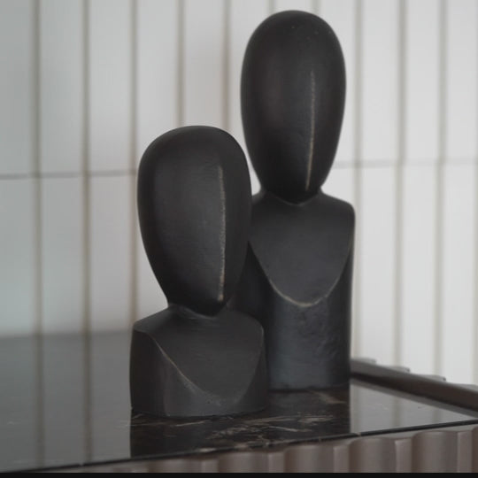 Zoomed in video of a pair of two black colored abstract faces used for table-top decor.