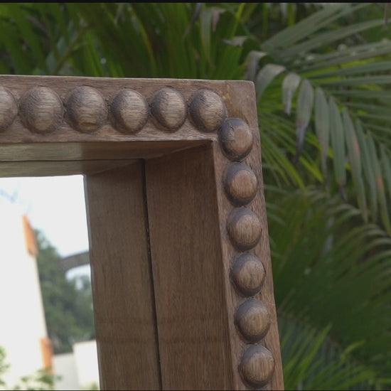 Zoomed in video showing detailed wood work on a mirror.