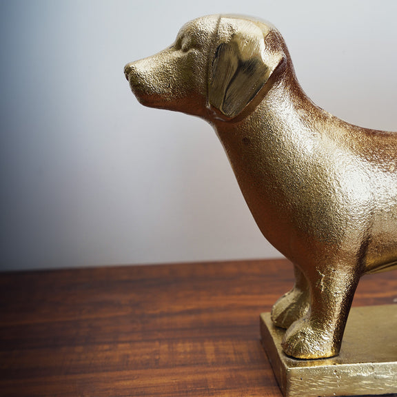 Side angle of a dog shaped golden bookend.