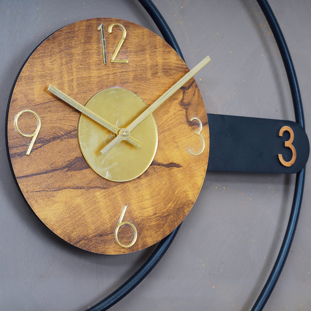 Close up view of a modern design large metallic wall clock in rings shape design.