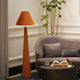 Orange colored velvet floor lamp is placed in a living room set-up.