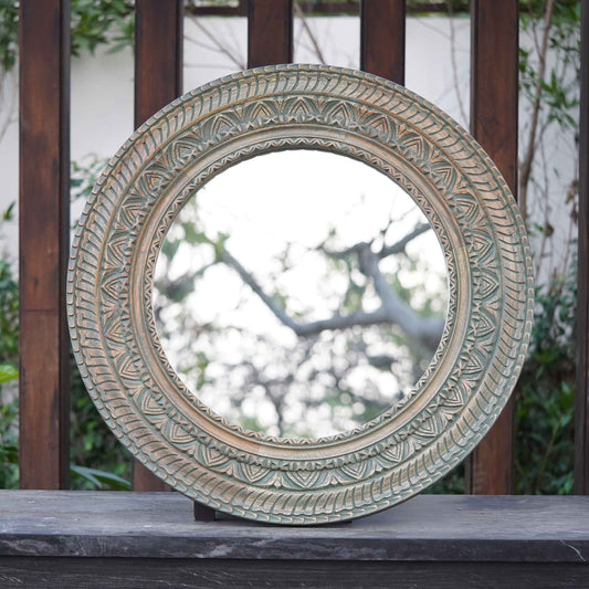 Large circular mirror in hand-carved mango wood frame- front view.