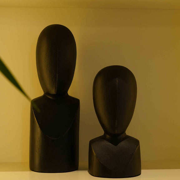 Close view of a pair of two black colored abstract faces as table-top decor.