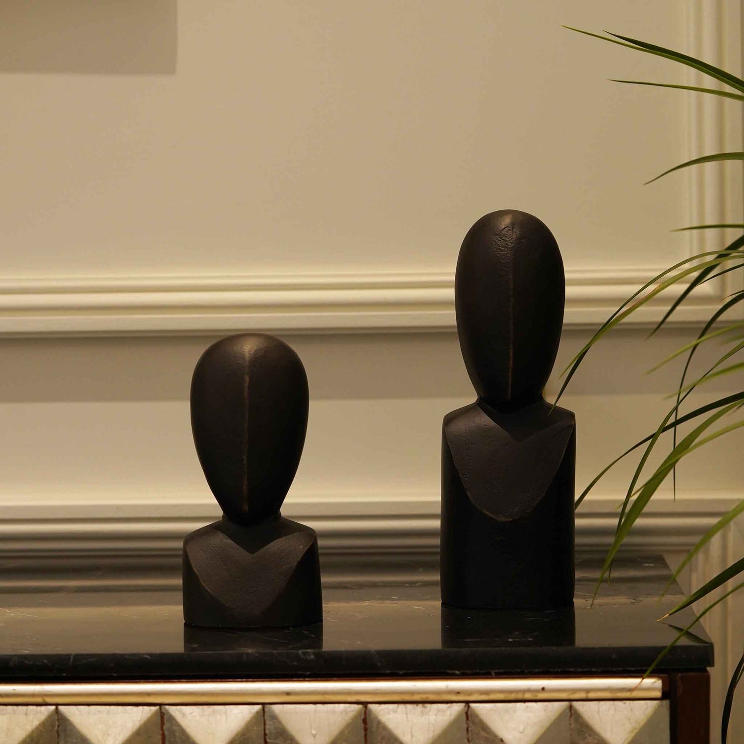 Pair of two black colored abstract faces as table-top decor.