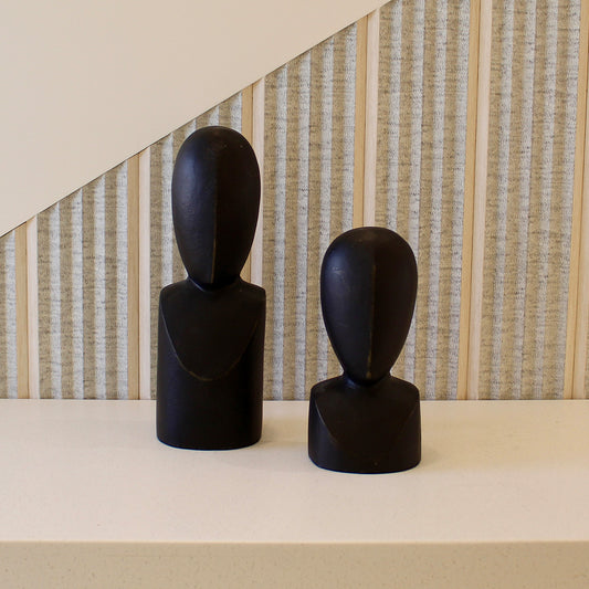 A pair of two black colored abstract faces as table-top decor.