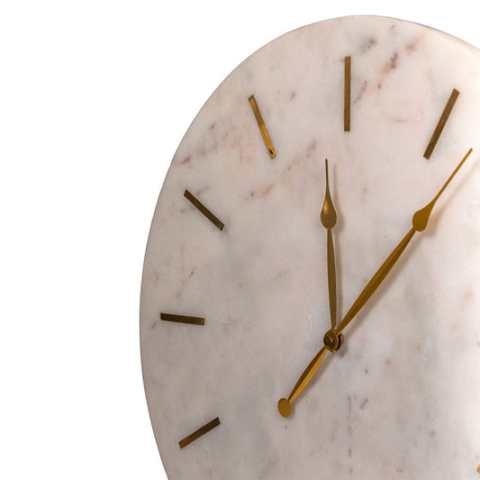 Close-up of a large and heavy white marble clock with golden hands and hours marked with brass inlay in a plain white background.