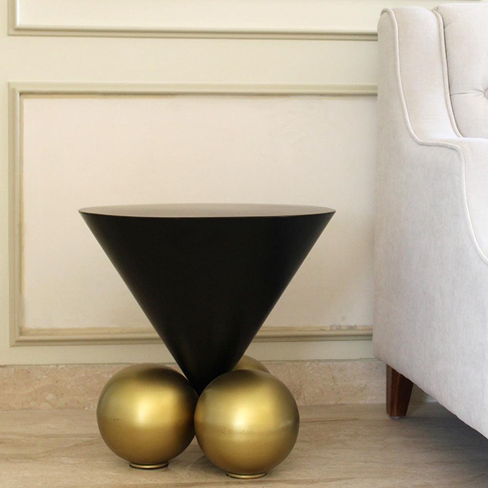 Modern design black triangle cone coffee table with 3 spherical balls on base in a living room setup.