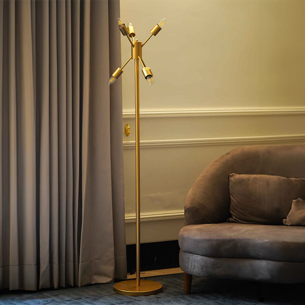 A golden colored modern floor lamp with 6 bulbs is placed in a living room.