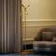 A golden colored modern floor lamp with 6 bulbs is placed in a living room.