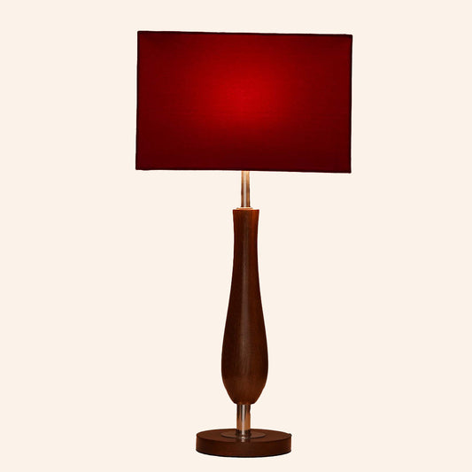 Wooden table lamp with red shade in a plain background.