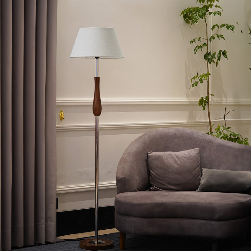 Tall floor lamp in metal and wood with a light blue lampshade in a living room.